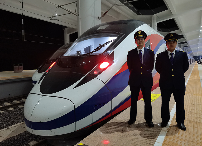 劉銀能（右一）與中國師父鄔俊鴻在動(dòng)車組前合影。受訪者供圖